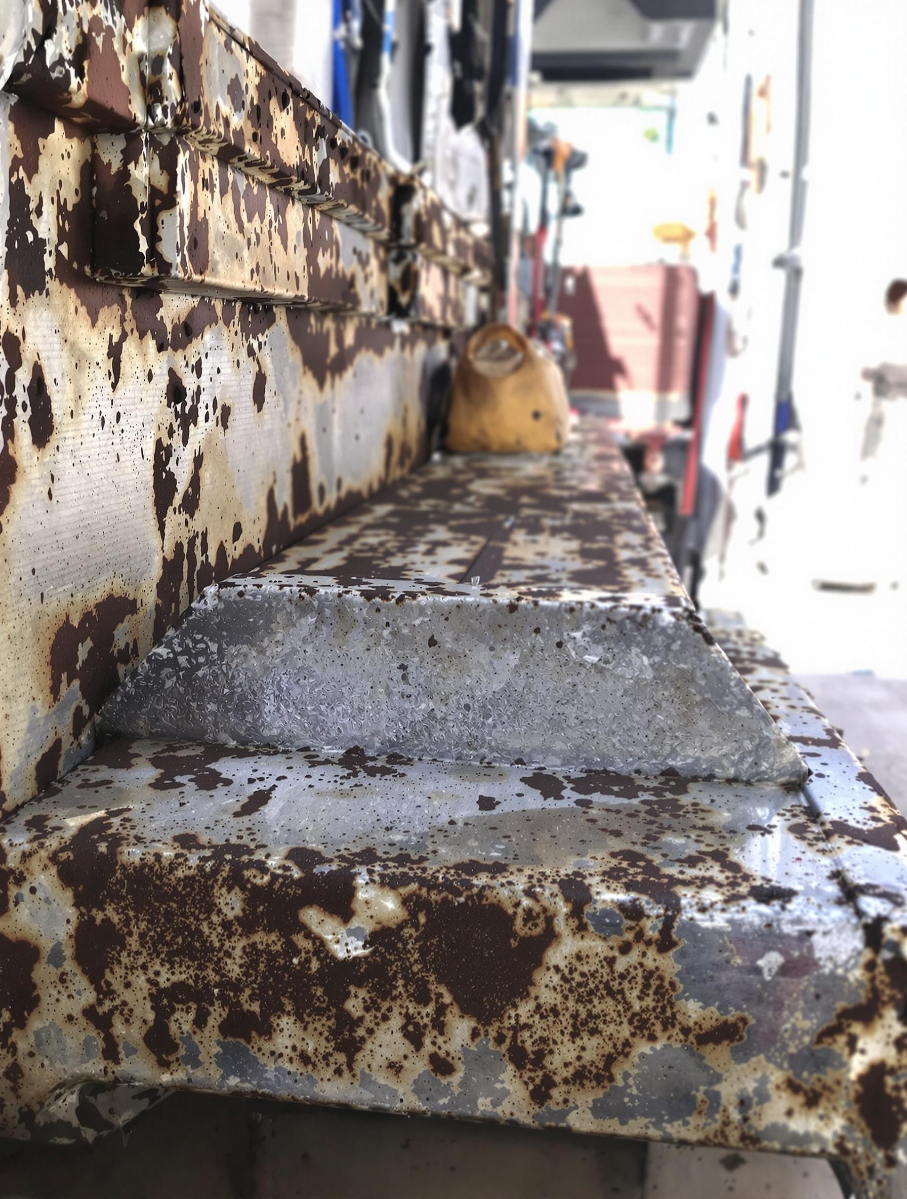 Corrosion visible sous un marchepied intérieur de fourgon d’occasion.